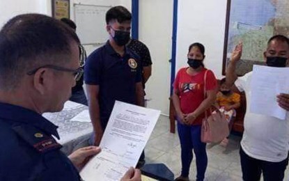 <p><strong>‘URBAN OPERATOR’.</strong> Ruel Boralo, 44, an alleged urban operator of the New People's Army (right), surrenders to police authorities Thursday (Dec. 8, 2022) in Leon Postigo, Zamboanga del Norte. Personnel of the Zamboanga del Norte Police Provincial Office and the Army's 5th Special Forces Battalion facilitated his surrender. (<em>Photo courtesy of Area Police Command-Western Mindanao)</em></p>