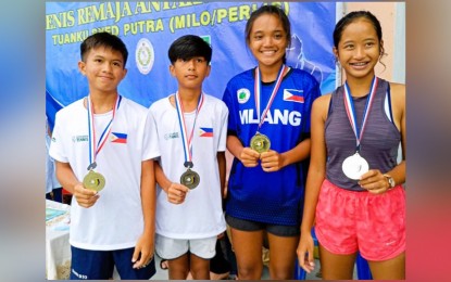 <p><strong>CHAMPIONS</strong>: Josh Benedict Lim, Aaron Kevin Tabura, Tennielle Bedua Madis, and Eidlemar Dane Basijan (from left) pose with their gold medals during the awarding ceremony of the Perlis-MILO International Junior Tennis Championships. The tournament was held in Malaysia on Friday (Dec. 9, 2022). <em>(Contributed photo) </em></p>