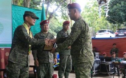 <p><strong>GOOD JOB.</strong> AFP chief-of-staff Lt. Gen. Bartolome Vicente Bacarro (left) gives an award to a troop of 1st Brigade Combat Team (1BCT) during its fourth anniversary rites at its headquarters in Sultan Kudarat, Maguindanao del Norte on Dec. 9, 2022. The 1BCT is the Philippine Army’s contingency force that is capable of addressing conventional, unconventional, and asymmetric threats. <em>(Photo courtesy of AFP)</em></p>