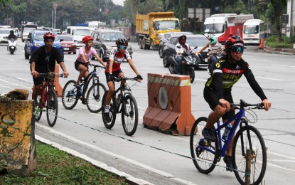 <p><strong>BIKE LANE</strong>. Cyclists pedal their way to work along the busy Elliptical Road in Quezon City on Dec. 12, 2022. Quezon City Rep. Marvin Rillo on Tuesday (Jan. 2, 2024) said Congress has increased to PHP1 billion the funding for the Active Transport and Safe Pathways Program to accelerate the development of protected bicycle lanes. <em>(PNA file photo by Jess M. Escaros Jr.)</em></p>
