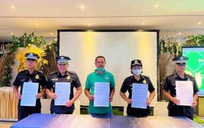 <p><strong>FOOD FOR INMATES</strong>. Officials of the Bureau of Jail Management and Penology (BJMP) in Sarangani province and a representative of Alkikan Vegetable Growers Association (ALVEGA), an agrarian reform beneficiary organization, show the contract for marketing agreement after signing ceremonies on Dec. 9, 2022. This is the third year of partnership between the ALVEGA and the BJMP – Sarangani. <em>(Photo courtesy of DAR)</em></p>