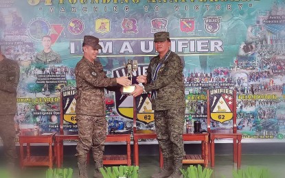 <p><strong>APPRECIATION</strong>. Lt. Col. William Pesase, commanding officer of the 62nd Infantry Battalion of the Philippine Army, hands over a token of appreciation to Brig. Gen. Inocencio Pasaporte during the battalion's anniversary celebration on Monday (Dec. 13, 2022). The Army official said the Communist insurgency in Negros island is now dwindling as government efforts, such as infrastructure projects, have helped to improve the peace and order in the area. <em>(PNA photo by Judy Flores Partlow)</em></p>