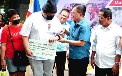 <p><strong>MALASAKIT</strong>. Ronald Patrick Sesma (center left) of San Juan Movement for Change Credit and Savings Cooperative receives on Thursday (Dec. 15, 2022) a PHP20,000 check as medical assistance from the officials of Cooperative Development Authority (CDA) with Senator Christopher Lawrence Go (center right). Sesma is among the 16 first batch beneficaries of Program on Medical Assistance for Cooperatives launched at CDA office in Cubao, Quezon City. <em>(PNA photo by Ben Briones)</em> </p>