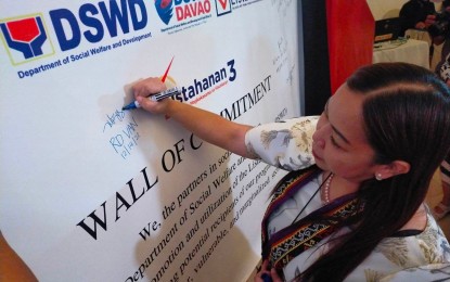 <p><strong>COMMITMENT WALL.</strong> Department of Social Welfare and Development in Davao Region Director Vanessa Goc-ong leads the signing of the commitment wall on Wednesday (Dec. 14, 2022), for the proper utilization of the Listahanan database. The database for poor households is used by government agencies and organizations that deliver social protection programs and services.<em> (PNA photo by Robinson Niñal Jr.)</em></p>