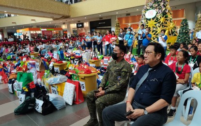 <p><strong>WISH COME TRUE</strong>. A total of 150 children from areas previously affected by the communist insurgency in Negros Oriental receive Christmas gifts at a mall in Dumaguete City under the Wish Upon A Star project on Dec. 15, 2022. Lt. Col. Roderick Salayo, commanding officer of the Army's 11th Infantry Battalion and Dr. Dino Depositario, deputy city administrator (left to right), are shown in photo together with the children.<em> (Photo by Judy Flores Partlow)</em></p>