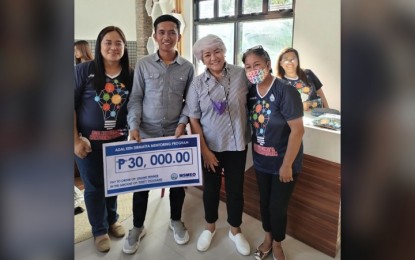 <p><strong>PAKBET CRACKERS</strong>. Marvin Vea receives the PHP30,000 cash prize for his "pakbet crackers." With him in the photo are Micro, Small, and Medium Enterprises Office head Elma Gabriel, Ilocos Norte Vice Governor Cecilia Araneta Marcos, and provincial social welfare and development officer Lilian Rin. <em>(Contributed)</em></p>