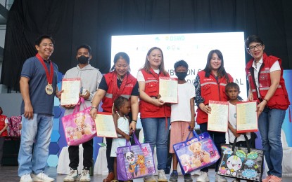 <p><strong>SERVICES CARAVAN.</strong> Lapu-Lapu City Mayor Junard Chan poses with the children, heads of family and Department of Social Welfare and Department (DSWD) officials during the inter-agency service and information caravan at the Hoops Dome in Lapu-Lapu City, Cebu last Dec. 21, 2022. The DSWD said on Friday (Dec. 23) the caravan provided services and information to 200 children and 400 heads of family as well as indigenous peoples in street situations.<em> (Photo courtesy of DSWD-7)</em></p>