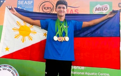 <p><strong>GOLDEN PERFORMANCE.</strong> Filipino-German Alexander Georg Eichler holds the Philippine flag after winning three gold, one silver and two bronze medals in the 44th Southeast Asian Age Group Swimming Championships at the National Aquatic Center in Kuala Lumpur, Malaysia held from Dec. 17 to 19, 2022. The 15-year-old Eichler was born to a Filipino mother and a German father.<em> (Contributed photo)</em></p>