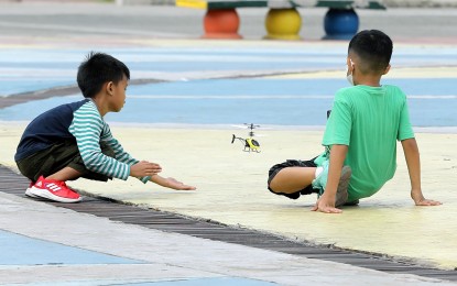 <p><strong>PLAY TIME.</strong> These boys play with their electric toy helicopter at the Quezon Memorial Circle on Dec. 26, 2022. Health experts said young children may suffer from myopia if they lack enough time to play outdoors. <em>(PNA photo by Joey O. Razon)</em></p>