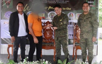 <p><strong>SURRENDER.</strong> A New People's Army (NPA) rebel turns over his firearm to Brig. Gen Aldwine Almase, 903rd Brigade Commander (second from right) in Castilla town, Sorsogon province on Sunday (Dec. 25, 2022). Also in photo are Barcelona town councilor Rico Falcotelo (left) and Lt. Col. Marlon Mojica (right). <em>(Photo courtesy of 903rd Brigade CMO)</em></p>