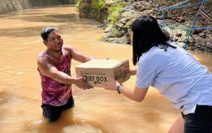 <p><strong>RELIEF BOX</strong>. A man wades through floodwater to get a relief box from personnel of the Office of the Vice President - Disaster Operations Center (OVP-DOC) in Zamboanga City on Monday (Dec. 26, 2022). Several areas in the city were flooded following heavy rains due to the shear line over the Christmas weekend. <em>(Photo courtesy of Office of the Vice President)</em></p>