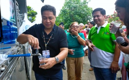 <p><strong>CLEAN WATER.</strong> Davao City Vice-Mayor Jay Melchor Quitain Jr.(left) tries the water produced by the air-to-water generator machine (AWG) after it was launched Wednesday (Dec. 28, 2022) in Bangkal, Davao City. The AWG machine converts atmospheric air into potable water that may be used for emergency purposes, especially during disasters. <em>(PNA photo by Robinson Niñal Jr.)</em></p>