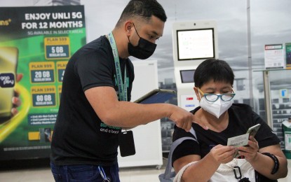 <p><strong>SIM REGISTRATION</strong>. A Smart employee assists a customer in registering her SIM card at the Smart store in Ali Mall, Quezon City on Dec. 28, 2022. The Department of Information and Communications Technology (DICT) on Thursday said over 10 percent of active mobile users in the country have so far completed their SIM card registration. <em>(PNA photo by Robert Oswald P. Alfiler)</em></p>