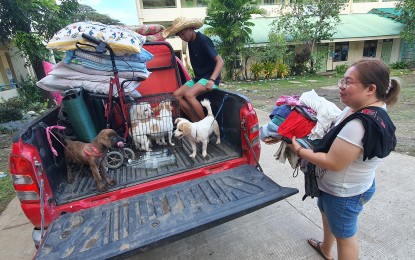 <p><strong>HOMEWARD BOUND.</strong> The Uy family packs their belongings on Thursday (Dec. 29, 2022) as the local government of Clarin in Misamis Occidental allowed 621 families to return to their homes. The family has yet to recover after its livestock and livelihood were destroyed by the flooding, caused by the shear line rains from Dec. 24-25, 2022 in the area. <em>(PNA photo by Nef Luczon)</em></p>