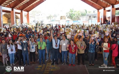 <p><strong>JOYOUS DAY. </strong>Agrarian reform farmer-beneficiaries wave their land titles awarded to them by the Department of Agrarian Reform in Rosales town, Pangasinan on Wednesday (Dec. 28, 2022). Some of them also received farm machinery and inputs from DAR. <em>(Photo courtesy of DAR Pangasinan) </em></p>