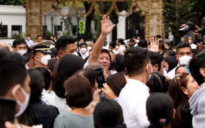 <p><strong>APPRECIATION</strong>. President Ferdinand R. Marcos Jr. waves to families of overseas Filipino workers during the “Pamaskong Handog Para sa Pamilyang OFW” at the Kalayaan grounds of Malacañang Palace in Manila on Friday (Dec. 30, 2022). The gift-giving event marks the first anniversary since the signing of the law that created the Department of Migrant Workers. <em>(PNA photo by Rey S. Baniquet)</em></p>