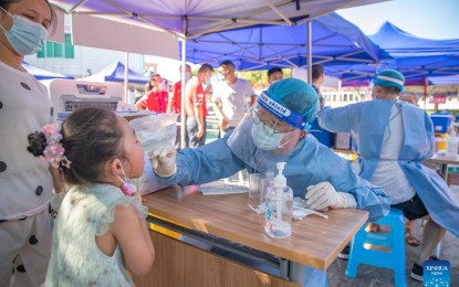 <p><strong>PRECAUTION.</strong> A medical worker takes a swab sample from a child for nucleic acid test in Liangjiang New District, Chongqing, China on Aug. 24, 2022. China will cancel nucleic acid tests for international arrivals starting Jan. 8, 2023 whle those with with an abnormal health status declaration or fever symptoms will receive an antigen test. <em>(Xinhua/Huang Wei)</em></p>