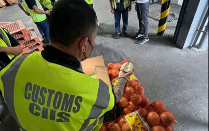 <p class="p1"><span class="s1"><strong>SMUGGLED.</strong> Members of the Customs Intelligence and Investigation Service-Manila International Container Port (CIIS-MICP) inspect boxes of smuggled fresh red and white onions from China estimated to be worth PHP139.7 million. The shipments arrived between Nov. 27 and Dec. 3, 2022 at the Manila International Container Port (MICP) and were consigned to Taculog J International Consumer Goods Trading.<strong> </strong></span><em><span class="s1">(Photo from BOC) </span></em></p>