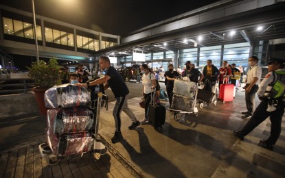 <p><strong>STRANDED.</strong> Some stranded passengers whose flights were cancelled go back home from Ninoy Aquino International Airport Terminal 3 in Pasay City on Sunday (Jan. 1, 2023). The massive glitch at the air control system canceled or delayed some 288 flights and affected about 65,000 passengers. <em>(PNA photo by Avito Dalan)</em></p>