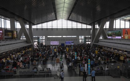 <p><strong>DISRUPTED.</strong> Passengers at the NAIA Terminal 3 in Pasay City queue at the check-in counter as it resumes its operation on Monday, (Jan. 2, 2023), following a technical issue in the Air Traffic Management Center of the Civil Aviation Authority of the Philippines on New Year's Day. Some senators have filed resolutions seeking a probe of the incident that disrupted flights.<em> (PNA photo by Yancy Lim)</em></p>