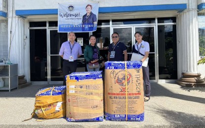 <p><strong>‘BALIKBAYAN’ BOXES.</strong> A consignee (second from left) is seen in this Tuesday (Jan. 3, 2023) photo claiming balikbayan boxes from Bureau of Customs-Subport of Mactan Collector Gerardo Campo (third from left). These packages were part of the 185 abandoned balikbayan boxes ordered by Customs Commissioner Yogi Filemon Ruiz to be distributed for free to the consignees in Central Visayas. <em>(Photo courtesy of BOC Collector Gerardo Campo)</em></p>