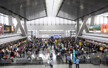 <p><strong>TECHNICAL GLITCH</strong>. Passengers at NAIA Terminal 3 in Pasay City queue at the check-in counter as it resumes its operation after the Air Traffic Management Center of the Civil Aviation Authority of the Philippines experienced a technical glitch on Jan. 1, 2023. The incident affected over 56,000 passengers. <em>(PNA photo by Yancy Lim)</em></p>