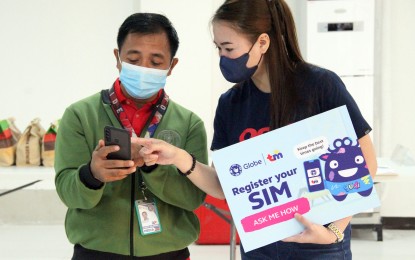 <p><strong>SIM REGISTRATION.</strong> A Globe personnel assists a mobile user in registering his SIM card during an NTC press conference at the NTC Building in Diliman, Quezon City on Jan. 6, 2023. Mobile users who lost or had their SIM cards stolen may request to have it reactivated in a new SIM card with their telecommunications provider. <em>(PNA photo by Robert Alfiler)</em></p>