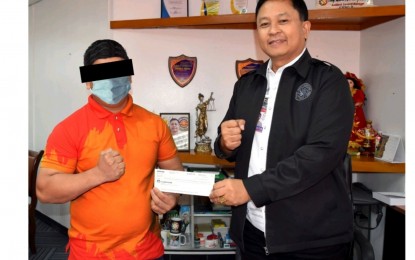 <p><strong>WINNER.</strong> PCSO Assistant General Manager for Administrative Sector Lauro Patiag (right) on Jan. 3, 2023 hands over the check worth over PHP114 million to the winner of the Dec. 23, 2022 Mega Lotto 6/45 draw at the PCSO main office in Mandaluyong City. The new millionaire revealed that he has been a regular lotto player for 15 years and that his winning combination consists of his favorite numbers. <em>(Photo courtesy of PCSO)</em></p>