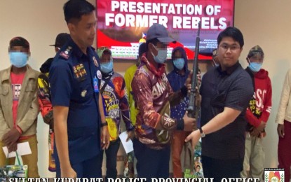 <p><strong>INTO THE MAINSTREAM.</strong> A member of the communist New People’s Army (center) hands over his rifle to Sultan Kudarat Gov. Datu Pax Ali Mangudadatu (right) during surrender rites in Isulan, Sultan Kudarat, on Thursday afternoon (Jan. 12, 2023) as Col. Christopher Bermudez, provincial police director, looks on. At least 12 NPA rebels, all members of the NPA Platoon Arabo of Guerrilla Front Daguma, Far South Mindanao Region, surrendered during the event. <em>(Photo courtesy of Sultan Kudarat PPO)</em></p>