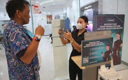 <p>A Smart Communications Inc. (Smart) staff assists a client in registering their SIM card at the Smart store in SM City Davao on Jan. 16, 2023. <em>(PNA photo by Robinson Niñal Jr.) </em></p>