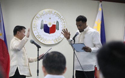 <p><strong>IMPORT NO MORE.</strong> Senator Francis Tolentino (left) administers the oath of allegiance to naturalized Justin Brownlee at the Senate on Monday (Jan. 16, 2023). The American-born Brownlee first came to the Philippines in 2016 as an import for Barangay Ginebra in the Philippine Basketball Association. <em>(PNA photo by Avito Dalan)</em></p>