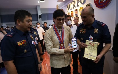 <p><strong>'SAFE ALERT APP'.</strong> DILG Secretary Benjamin Abalos Jr. (center) shows the S.A.F.E NCRPO APP Alert mobile application during its launch at the NCRPO headquarters at Camp Bagong Diwa, Taguig City on Monday (Jan. 16, 2023). The app is expected to facilitate a more effective and quick mechanism of reporting any crime. <em>(PNA photo by Lloyd Caliwan)</em></p>