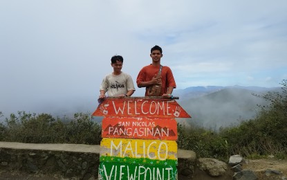 <p><strong>VIEWPOINT</strong>. Tourists pose for a photo at the viewpoint in Barangay Malico, overlooking Pangasinan province on Jan. 17, 2023. Tourists go to Malico to enjoy the cold weather and scenery in the area. <em>(Photo by Hilda Austria)</em></p>