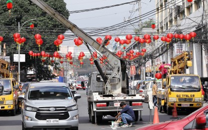 <p><strong>CHINESE NEW YEAR</strong>. Workers install Chinese lanterns along the intersection of Banawe Street and Quezon Avenue in Quezon City in preparation for the Chinese New Year on Wednesday (Jan.18, 2023). Chinese New Year festivity, which will culminate on Jan. 22, reminds the city's constituents of how Chinese culture and traditions have also enriched the Filipinos' customs. <em>(PNA photo by Joey O. Razon)</em></p>