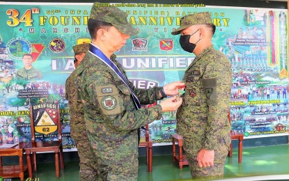 <p><strong>RECOGNITION</strong>. Maj. Gen. Benedict Arevalo (left), commander of the Philippine Army's 3rd Infantry Division, bestows the Military Merit Medal on personnel of the 62nd Infantry Battalion during the pinning rites held at the unit's headquarters in Isabela, Negros Occidental on Wednesday (Jan. 18, 2022). A total of 117 soldiers and policemen were recognized by the 3ID for successful operations against the New People's Army in central Negros in the past three months. <em>(Photo courtesy of 62nd Infantry Battalion, Philippine Army)</em></p>