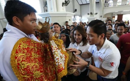 <p><strong>SINULOG IN CARMEN.</strong> Governor Gwendolyn Garcia (center) and 5th District Representative Vincent Franco Frasco (right) are seen kissing an image of the Sr. Sto. Niño in a church in Carmen, a town north in Cebu province, in this file photo. Mayor Carlo Villamor on Thursday (Jan. 19, 2023) said Garcia is expected to offer a dance ritual with the contingent from Consolacion that will perform the grand finale for the Sinulog Festival in Carmen on Sunday. <em>(Photo courtesy of Cebu City PIO)</em></p>