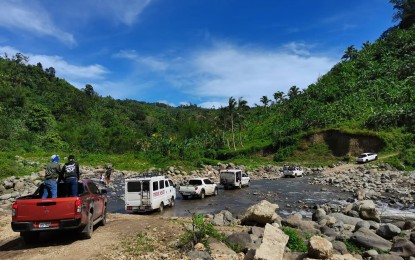 <p><strong>ROAD PROJECT</strong> A convoy of government vehicles traverses a rough road and crosses a river in Tamlang Valley in Santa Catalina, Negros Oriental province during a local peace engagement on Dec. 16, 2022. The provincial government is allocating a PHP300 million budget for the concreting and development of the road that connects several hinterland barangays in the towns of Santa Catalina, Valencia, Sibulan and Pamplona. <em>(File photo by Judy Flores Partlow)</em></p>