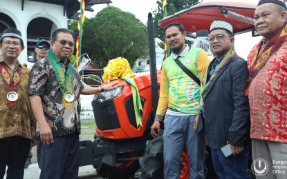 <p><strong>RAISING PRODUCTIVITY.</strong> Bangsamoro Autonomous Region in Muslim Mindanao (BARMM) Chief Minister Ahod Balawag Ebrahim (2nd from left) and Ministry of Agriculture, Fisheries and Agrarian Reform Minister Mohammad Yacob (left) hand over a tractor to the representatives of farmers’ cooperatives during the regional government's 4th founding anniversary on Sunday (Jan. 22, 2023). The inputs and equipment are aimed at raising the agricultural productivity of the region's farmers and fisherfolk. <em>(Photo courtesy of the Bangsamoro Information Office)</em></p>