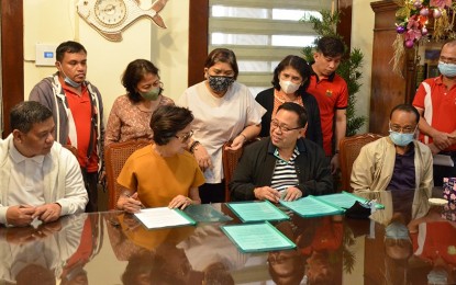 <p><strong>FARM DEVELOPMENT.</strong> Palo town Mayor Remedios Petilla (2nd from left) in Leyte province signs an agreement with Department of Agrarian Reform (DAR) assistant regional director Ismael Aya-ay (2nd from right) for the establishment of a greenhouse in this Jan. 20, 2023 photo. The department will finance the construction of a PHP1.5-million greenhouse in the town that will be managed by an agrarian reform beneficiaries organization. (<em>Photo courtesy of DAR)</em></p>