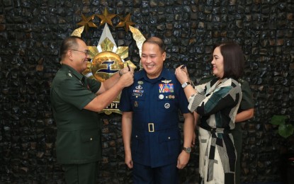 <p><strong>PROMOTED.</strong> Philippine Air Force (PAF) chief Lt. Gen. Stephen Parreño (center) receives his third star rank pinned by AFP chief Gen. Andres Centino (left) and his wife Mrs. Agnes Parreño (right) during the donning rites at the AFP General Headquarters on Monday (Jan. 23, 2023). Parreño was among the 21 senior officials of the PAF and the Philippine Navy who were promoted to the next higher rank. <em>(Photo courtesy of PAF)</em></p>