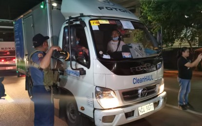 <p><strong>CHECKPOINT.</strong> A Cavite policeman is seen inspecting a vehicle at a checkpoint in Trece Martires City in connection with the special election on Feb. 25, 2023. Voters will choose their representative for the 7th Congressional District. <em>(PNA photo by Rossel Calderon)</em></p>