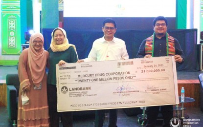 <p><strong>MEDS FOR INDIGENTS.</strong> Bangsamoro Autonomous Region in Muslim Mindanao Social Services Minister Raissa Jajurie (2nd left) and Mercury Drug Cotabato branch manager Daniel Ulep (2nd right) hold a check replica of PHP21 million representing the funds intended for the medicines of indigent patients. The handover on Thursday (Jan. 26, 2023) in Cotabato City aims to accelerate the delivery of health services to BARMM residents. <em>(Photo courtesy of Bangsamoro Information Office-BARMM)</em></p>