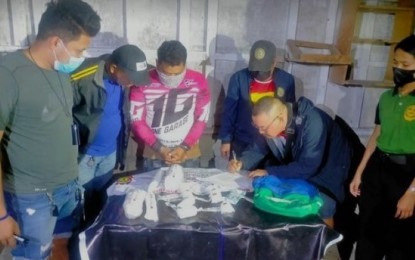 <p><strong>DRUG SUSPECT</strong>. Operatives from the Provincial Drug Enforcement Unit are seen conducting an on-site inventory of the two kilos of suspected shabu worth PHP13.6 million as the suspect, Lunicito Juario Labitad, alias “Looney” (third from left), 38, a resident of Barangay Quiot in Cebu City, looks on. Police Regional Office-7 chief, Brigadier General Jerry Bearis, on Friday (Jan. 27, 2023) said the arrest of Labitad, who belong to the "top 10 regional priority target", was one of the four drug personalities arrested in three separate operations in Cebu on Thursday night (Jan. 26) that yielded a total of PHP15.3 million worth of shabu. <em>(Photo courtesy of PRO-7)</em></p>