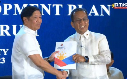 <p><strong>SOCIO-ECONOMIC TRANSFORMATION.</strong> President Ferdinand R. Marcos Jr. receives a copy of the Philippine Development Plan (PDP) 2023-2028 from National Economic and Development Authority Secretary Arsenio Balisacan at the Philippine International Convention Center in Pasay City on Monday (Jan. 30, 2023). Marcos said unburdening Filipinos from daily struggles remains a challenge for the government. <em>(Screengrab from RTVM)</em></p>