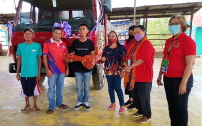 <p><strong>HAULER TRUCK.</strong> Sugarcane farmers’ association president Jenier Capindo of Matalam town holds the symbolic key of a hauler truck after receiving the donation from the Department of Agrarian Reform in North Cotabato last Jan. 27, 2023. With him are other association members and DAR officials.<em> (Photo courtesy of DAR-North Cotabato)</em></p>