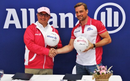 <p><strong>DEAL</strong>. Allianz PNB Life president and CEO Alexander Grenz (right) and Rebisco president Jonathan Ng shake hands during the partnership launching at the Ronac Living Gallery in Mandaluyong City on Monday (Jan. 30, 2023). The insurance company will sponsor the Creamline team in the Premier Volleyball League this year. <em>(PNA photo by Jesus Escaros Jr.)</em></p>