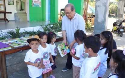<p><strong>CHILD-FRIENDLY</strong>. Batac City Vice Mayor Windell Chua distributes reading materials to Day Care pupils in this undated photo. The Batac city government is among the 14 localities in the province that will receive a child-friendly award on Feb. 2, 2023 for its programs and services promoting the health and welfare of the young.<em> (File photo courtesy of the city government of Batac)</em></p>
