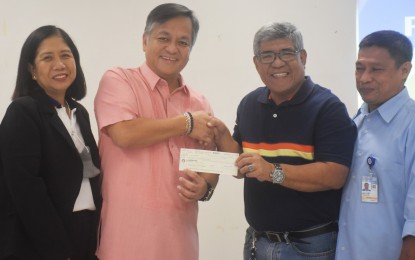 <p><strong>DEV'T PARTNERS.</strong> Department of Science and Technology-Bicol (DOST-5) Regional Director Rommel Serrano (second from left) hands over a check worth PHP160,000 to Dr. Luis Amano (second from right), Bicol University (BU) vice president for Research, Development and Extension on Monday (Jan. 30, 2023). The grant will support BU's programs benefiting women entrepreneurs and overseas Filipino workers.<em> (Photo courtesy of DOST-5)</em></p>