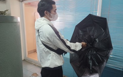 <p><strong>CLASSES SUSPENDED.</strong> A student prepares his umbrella before braving the rain in Cebu province on Wednesday (Feb. 1, 2023). Due to orange rainfall warning because of the shear line, the Provincial Disaster Risk Reduction and Management Office said 20 localities in Cebu province ordered the suspension of classes. (<em>PNA photo by John Rey Saavedra)</em></p>
