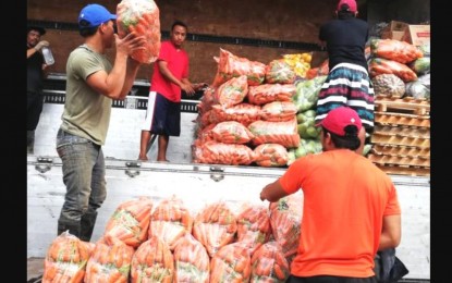 <p><strong>REGISTRATION</strong>. Vegetables are loaded onto a truck at the trading center in La Trinidad, Benguet for transport to Metro Manila and other parts of the country in this undated photo. Mayor Romeo Salda on Thursday (Feb. 2, 2023) said they are planning to require traders to register to prevent unscrupulous people posing as buyers from preying on farmers. <em>(PNA file photo by Liza T. Agoot)</em></p>